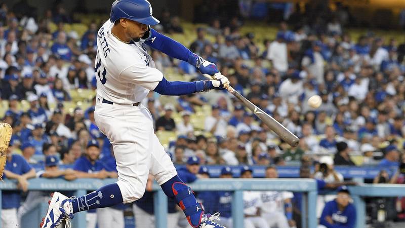 Los Angeles Dodgers' Mookie Betts hits a solo home run during the first inning of a baseball...