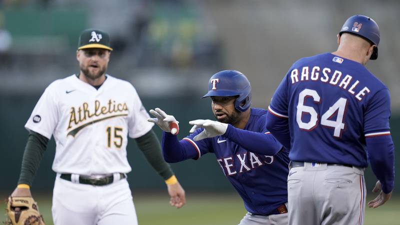 Texas Rangers' Ezequiel Duran, center, celebrates after hitting an RBI single against the...